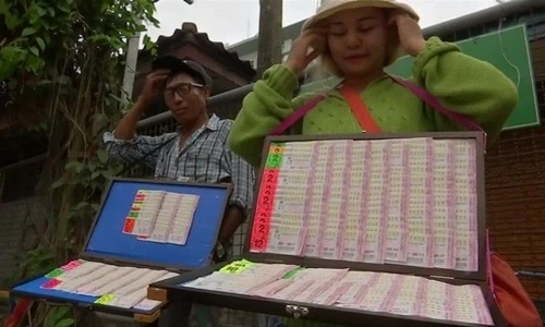 Sarirat Ladloy (phải) cho hay những người mua vé số gần đây thường tìm vận may từ những con số liên quan tới đội bóng nhí Thái Lan mắc kẹt trong hang. Ảnh: Reuters.