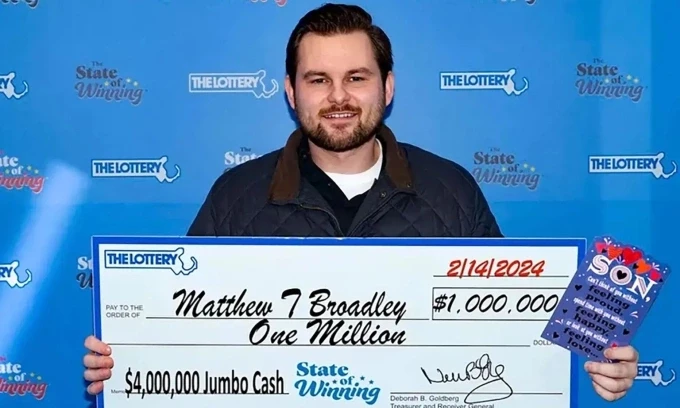 Matthew Broadley cầm theo thiệp chúc mừng ngày Valentine của mẹ khi nhận giải thưởng xổ số một triệu USD hôm 14/2. Ảnh: Xổ số bang Massachusetts